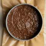 Batter for chocolate banana cake in a springform pan lined with parchment paper.