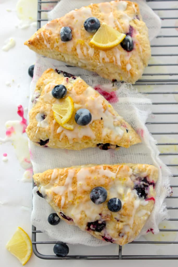 Blueberry lemon scones sitting on cheesecloth on a cookie sheet