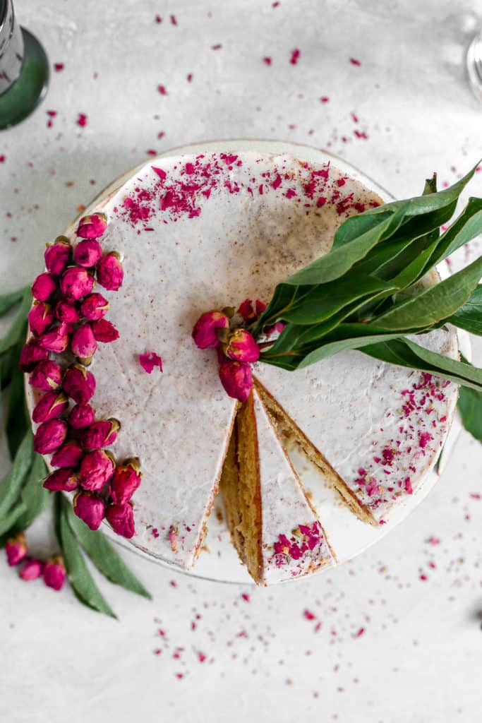 orange cardamom cake garnished with dried rose petals and frosted with rose buttercream frosting