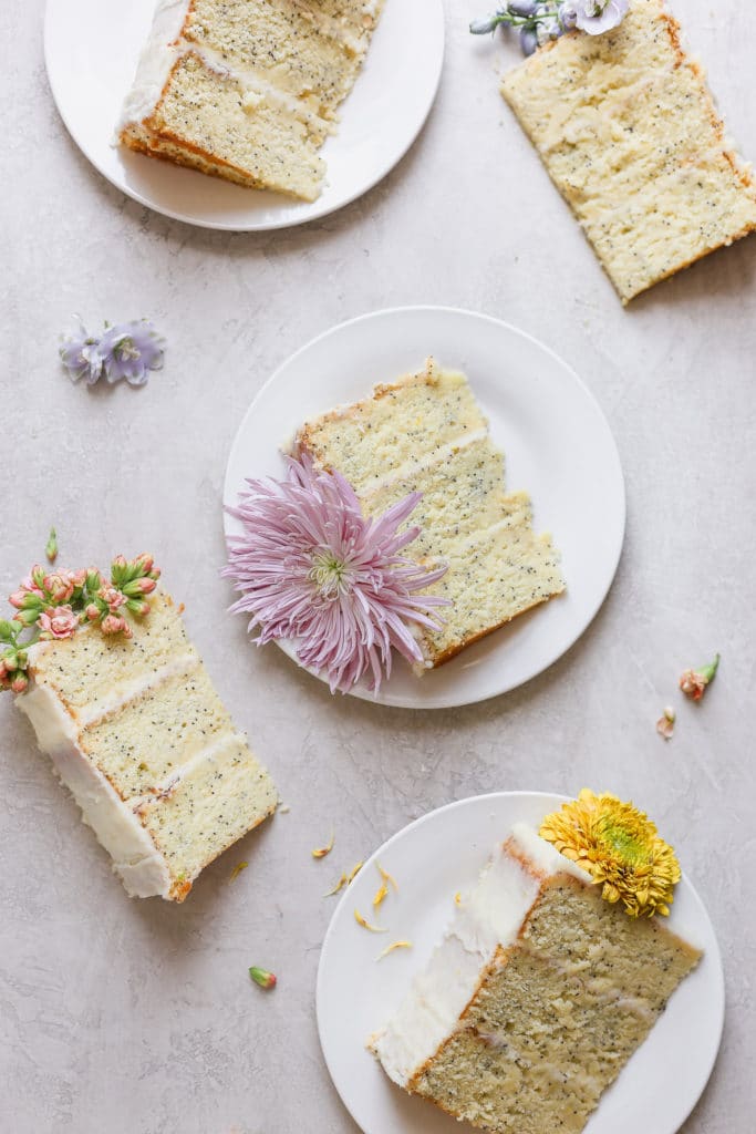 A lemon poppyseed cake on plates after demonstrating how to decorate a cake with flowers.