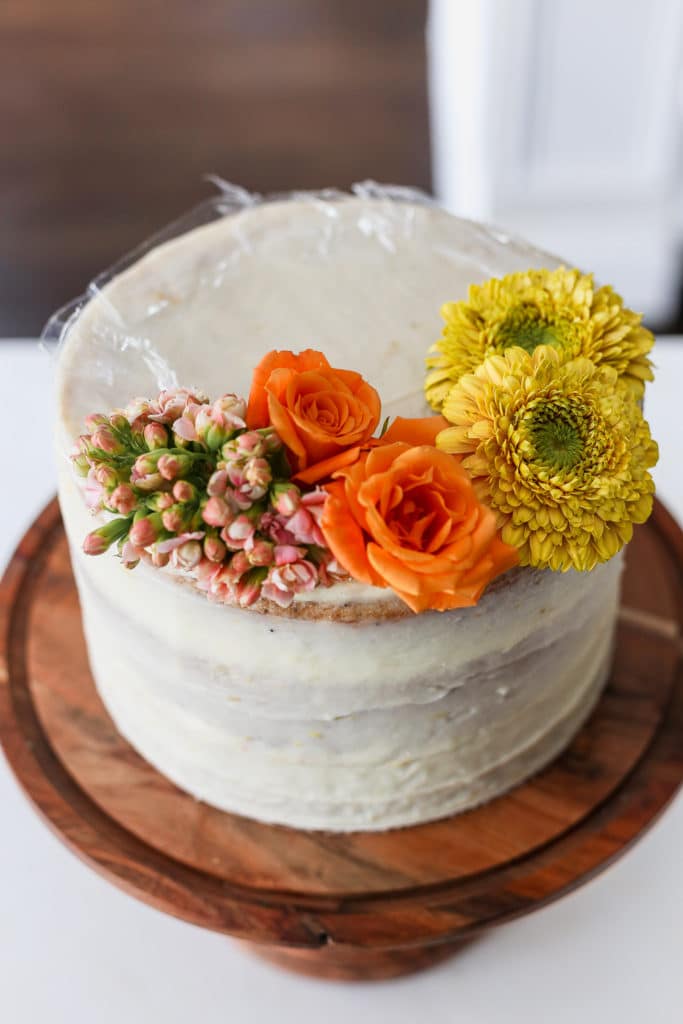 A white cake demonstrating how to decorate a cake with flowers.