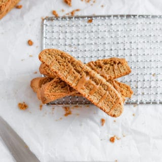 cookie butter biscotti layered on top of each other on a white background.
