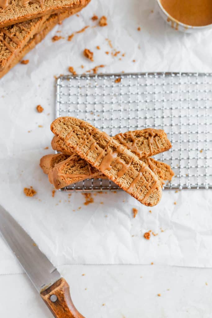 Three biscotti layered on top of each other on a small cookie sheet and white background.