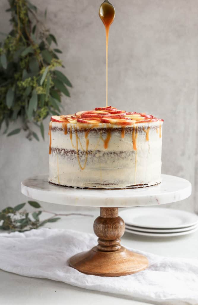 An white cake styled on a light background with dairy free caramel drizzling on top.