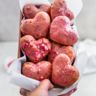 Strawberry heart donuts arranged in a loaf pan.