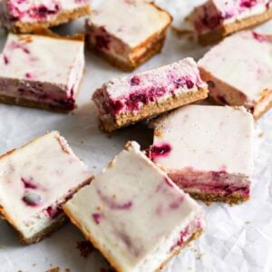 Cranberry cheesecake bars on parchment paper.