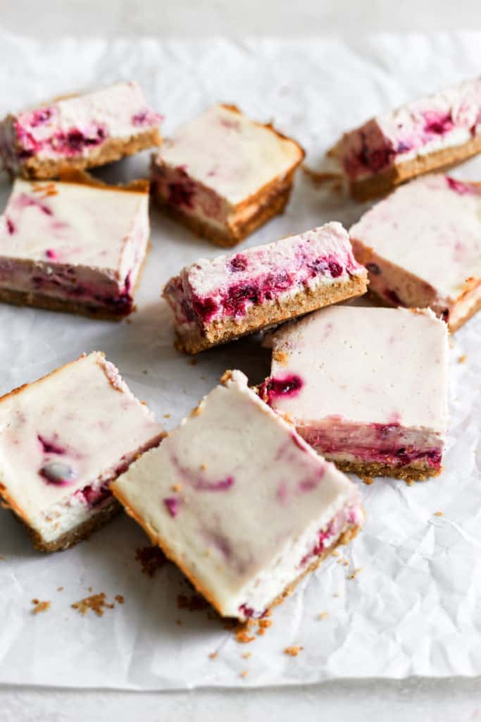 Cranberry cheesecake bars on parchment paper.