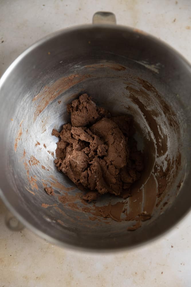 Chocolate cookie dough in a stainless steel mixing bowl.