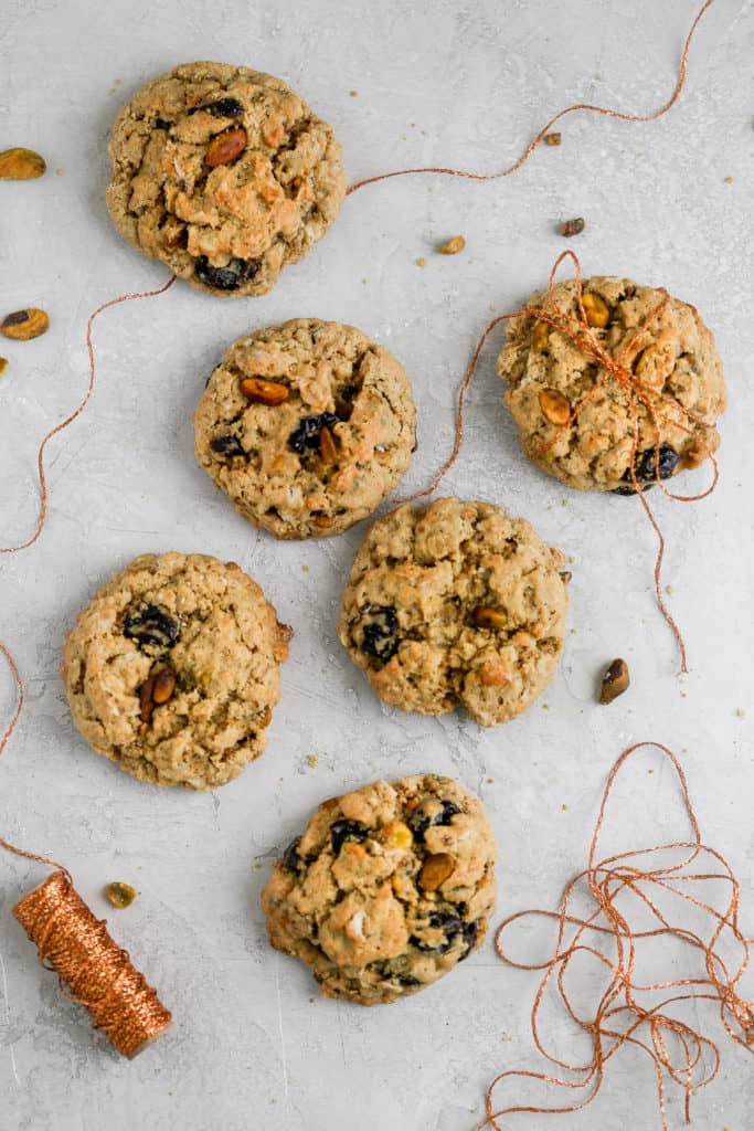 Cherry pistachio oatmeal cookies tied up with string displayed on a gray background