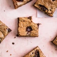 coffee chocolate chip blondie bars on a pink background.