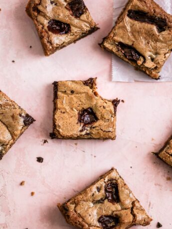 coffee chocolate chip blondie bars on a pink background.