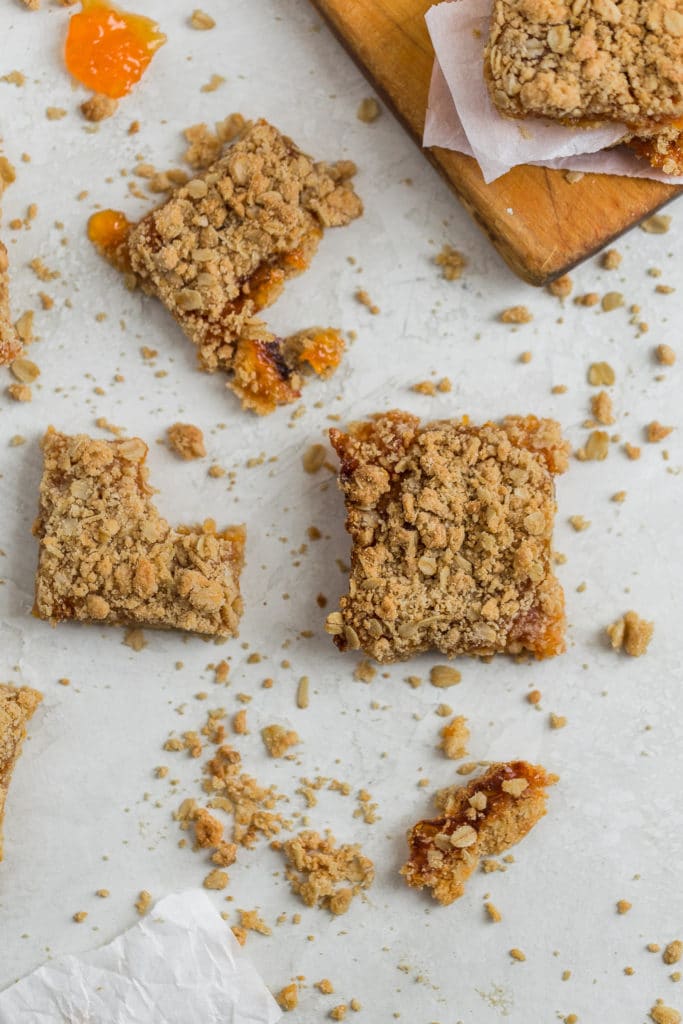 Apricot bars with bites in them on a gray surface