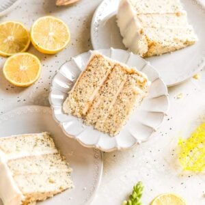 3 slices of lemon poppyseed cake styled on 3 gray plates on a gray background