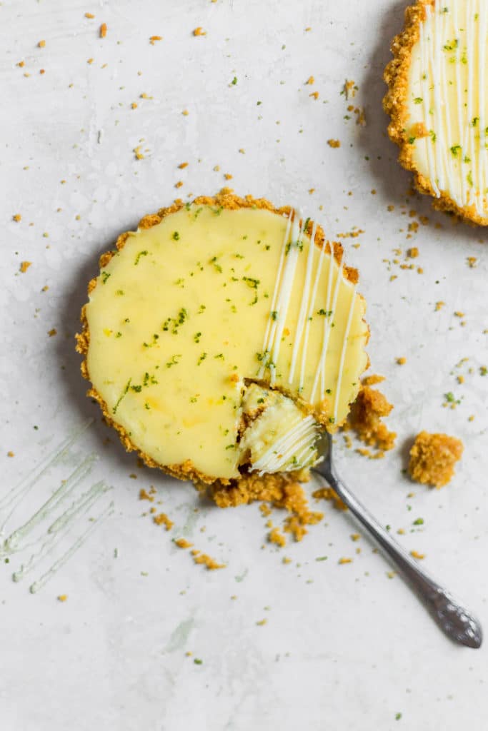A spoon taking a piece out of a mini key lime pie