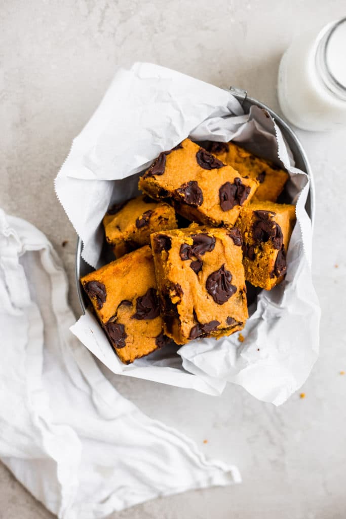 Pumpkin bars packed in a tin with parchment paper