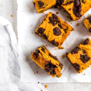 Pumpkin bars with chocolate chunks laid out on parchment paper