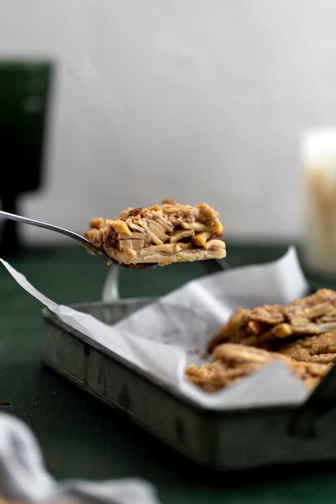 apple pie bar lifted out of a pan with a spatula