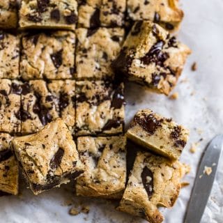 Blondies with chocolate chips cut up and put on its side to show you the melty chocolate inside.