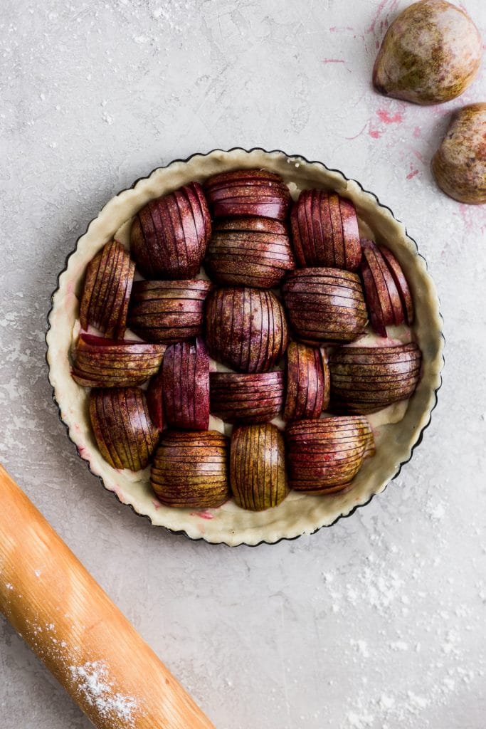 Sliced plums in an unbaked pie crust