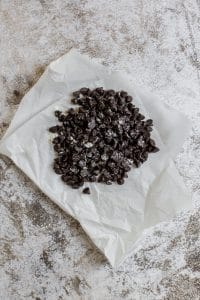 chocolate chips dusted with flour on parchment paper