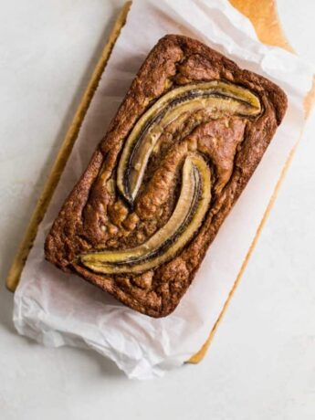 Baked banana bread with two slices of banana baked on top