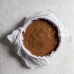 Chocolate cake batter in a parchment paper lined spring form pan