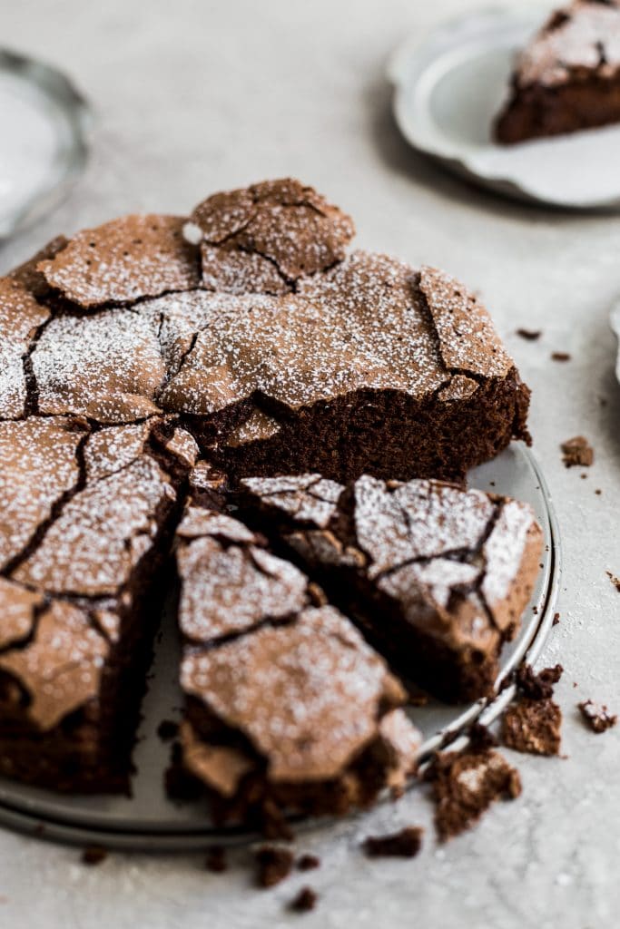 The top of a flourless chocolate cake with 2 slices cut out.