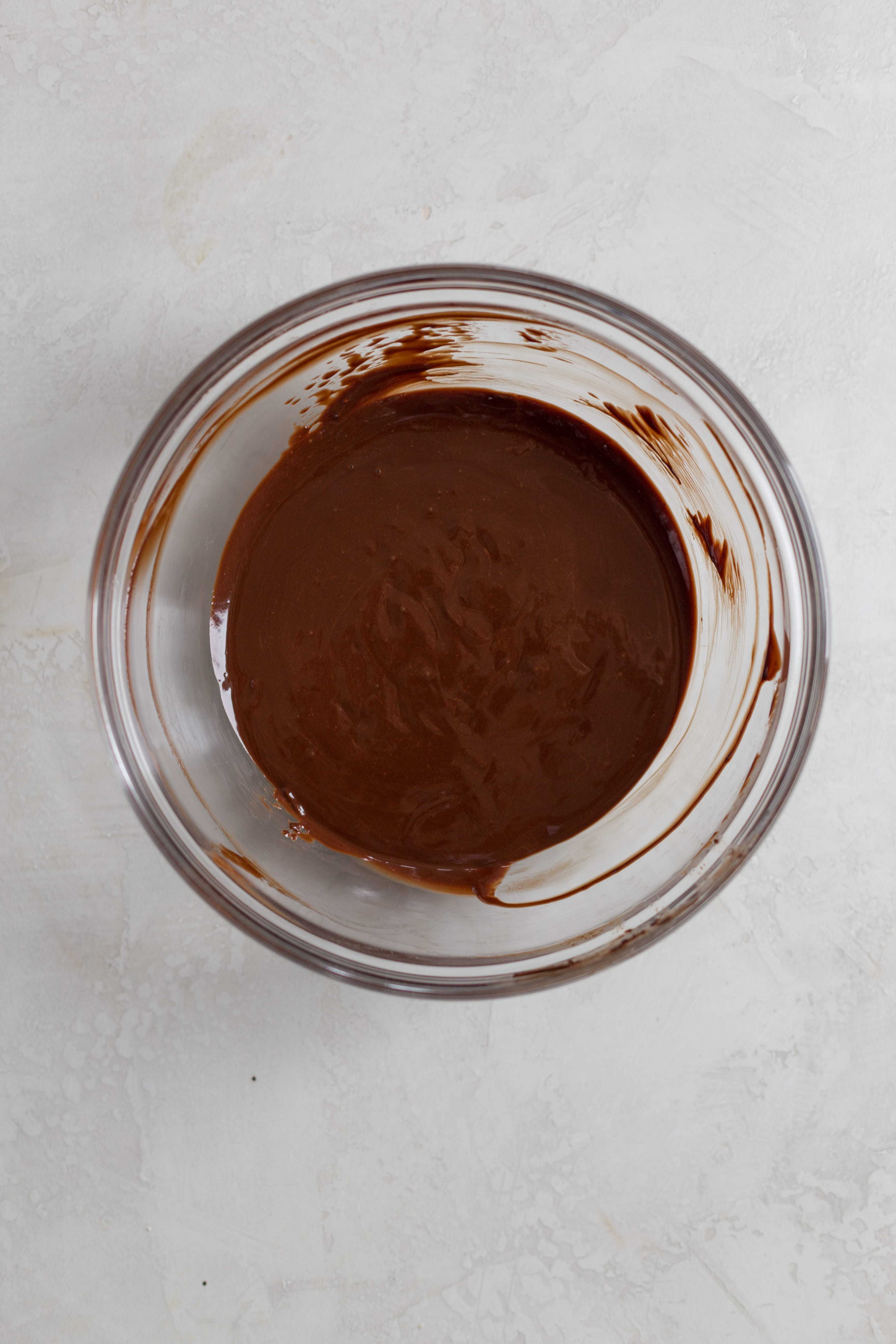 A glass bowl filled with melted chocolate