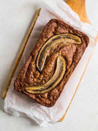 Baked banana bread with two slices of banana baked on top