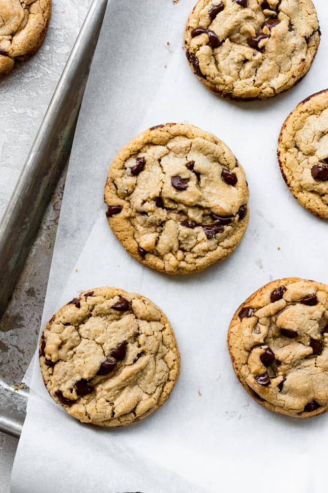 Chocolate chip cookies sitting on a parchment lined cookie tray
