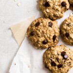 Cookies laying on two sheets on parchment paper on a gray background