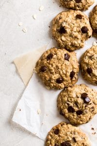 Cookies laying on two sheets on parchment paper on a gray background