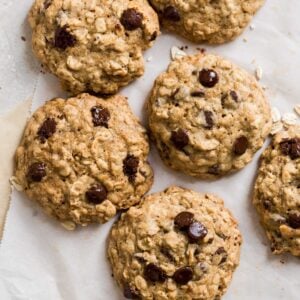 Cookies laying on two sheets on parchment paper on a gray background