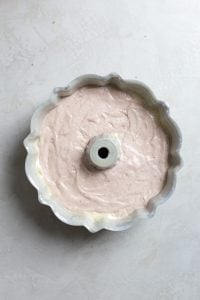 Cake batter in a bundt pan on a gray surface