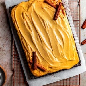 Chocolate cake with pumpkin cream cheese frosting and decorated with cinnamon sticks