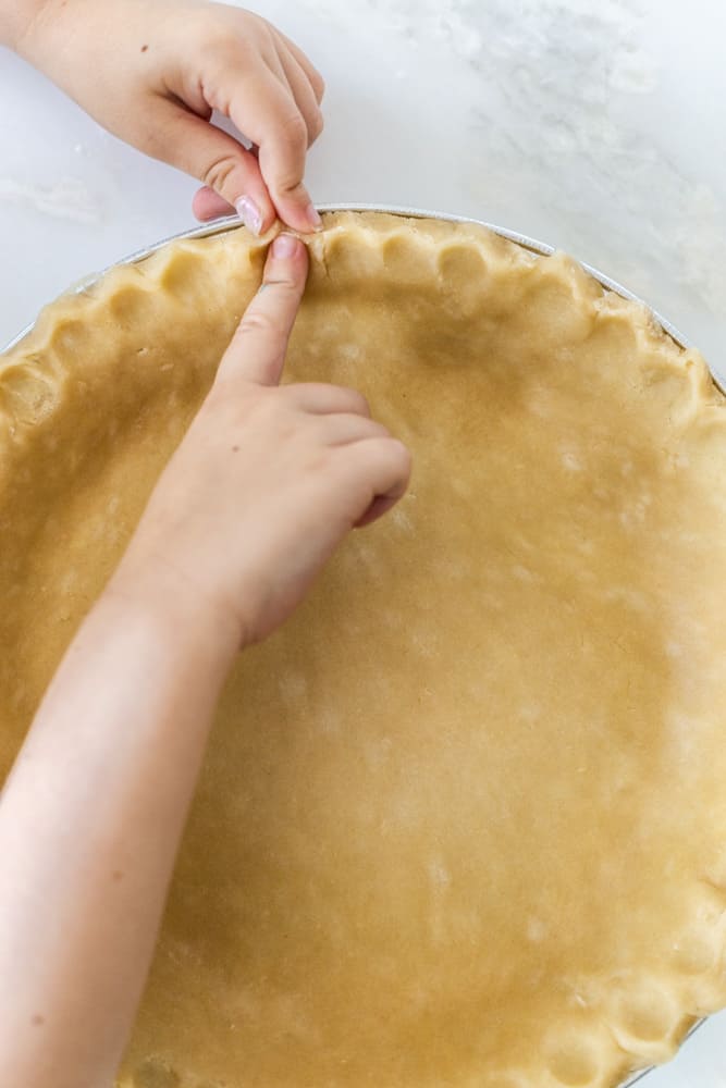 fingers crimping the edges of pie crust 