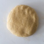 A disc of pie dough on a white surface