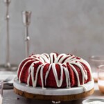 red velvet bundt cake on a marble and wood cake stand on a gray surface