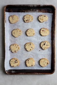 Sliced cookies on a parchment lined baking sheet