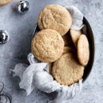 Eggnog snickerdoodles in a tray lined with cheesecloth on a textured background