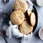 Eggnog snickerdoodles in a tray lined with cheesecloth on a textured background