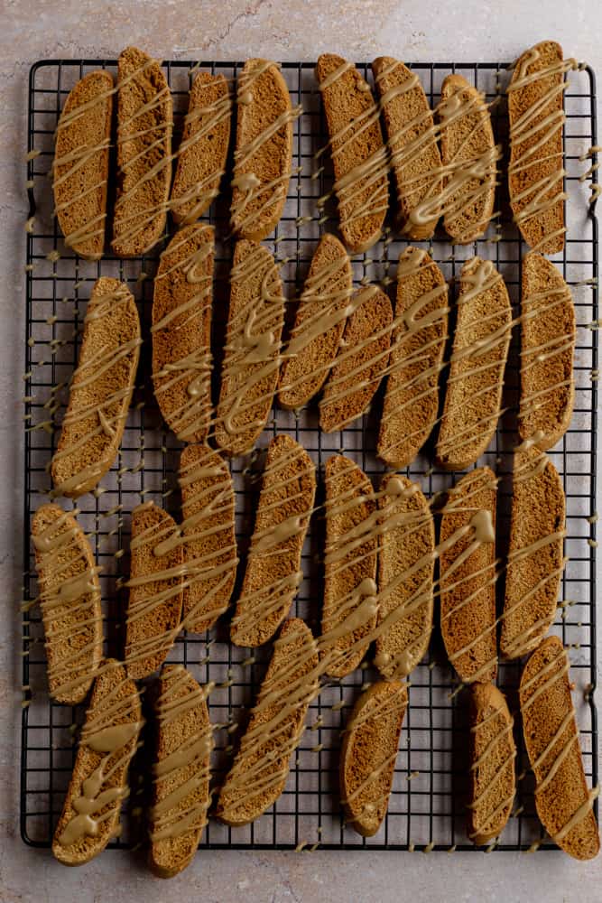 Glazed biscotti cookies on a black cookie sheet
