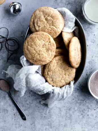 Eggnog snickerdoodles in a tray lined with cheesecloth on a textured background