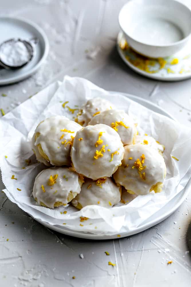 Glazed Italian ricotta cookies in a bowl lined with parchment paper