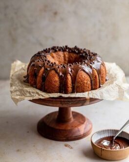 Banana Bundt cake with chocolate glaze on a wooden cake stand