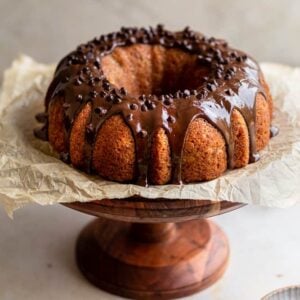 Banana Bundt cake with chocolate glaze on a wooden cake stand