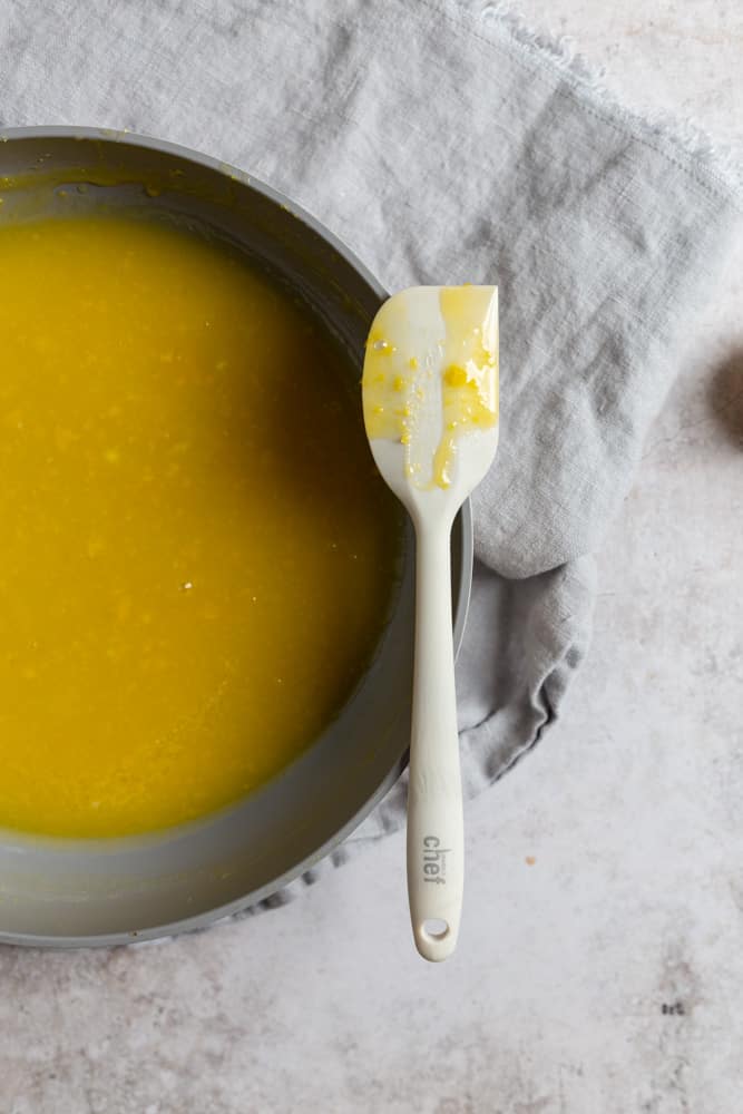A spatula resting on a pan of lemon curd