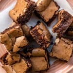 Fudgy brownies on a pink plate lined with parchment paper