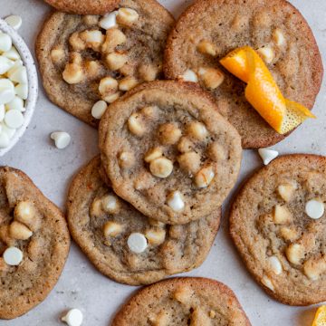 orange cookies with white chocolate chips on a gray surface