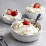 Mascarpone frosting in a bowl with a strawberry on top